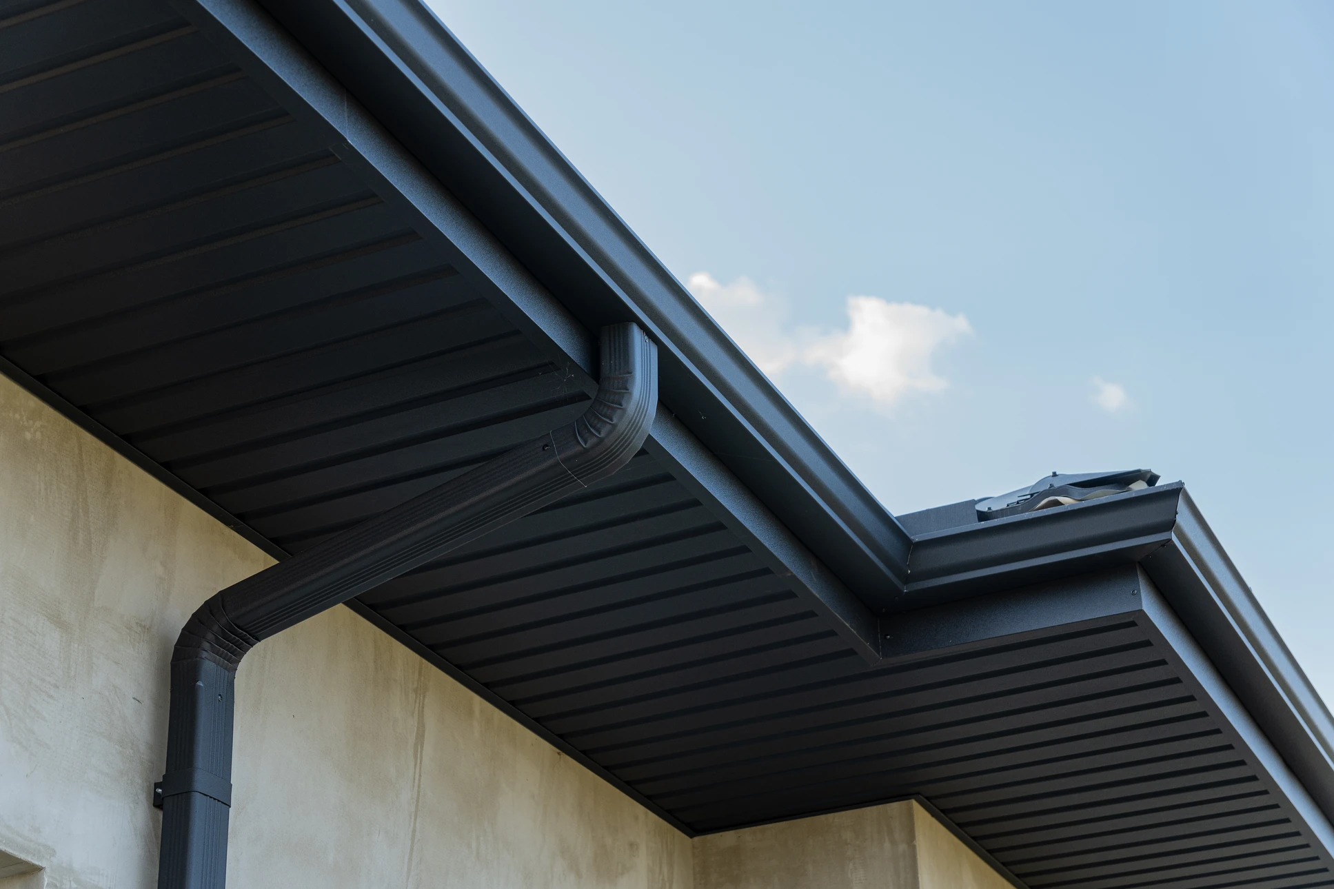Extérieur d'une habitation avec vue en contre-plongée sur la toiture et les éléments de zinguerie
